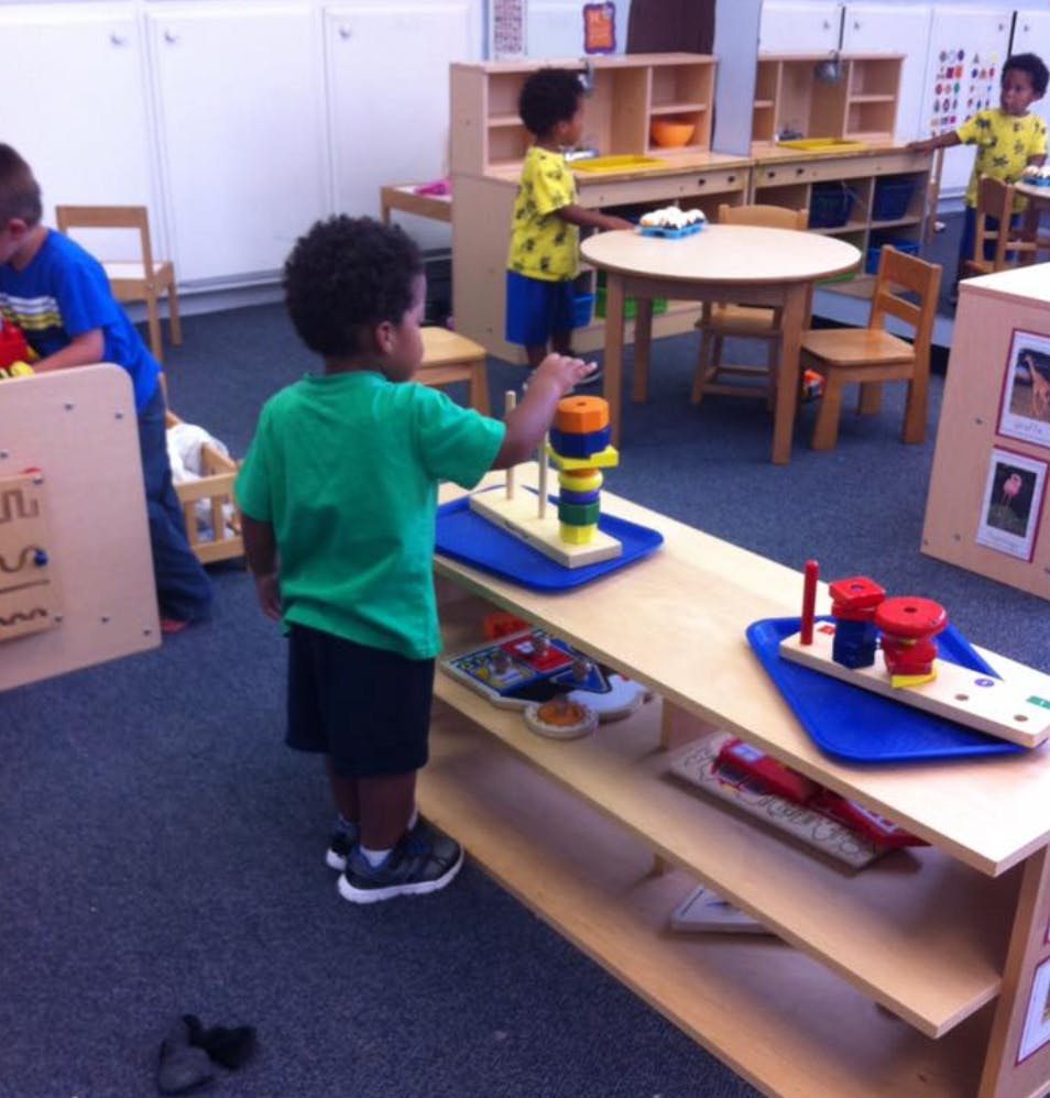 Child playing with a stacking toy in a classroom