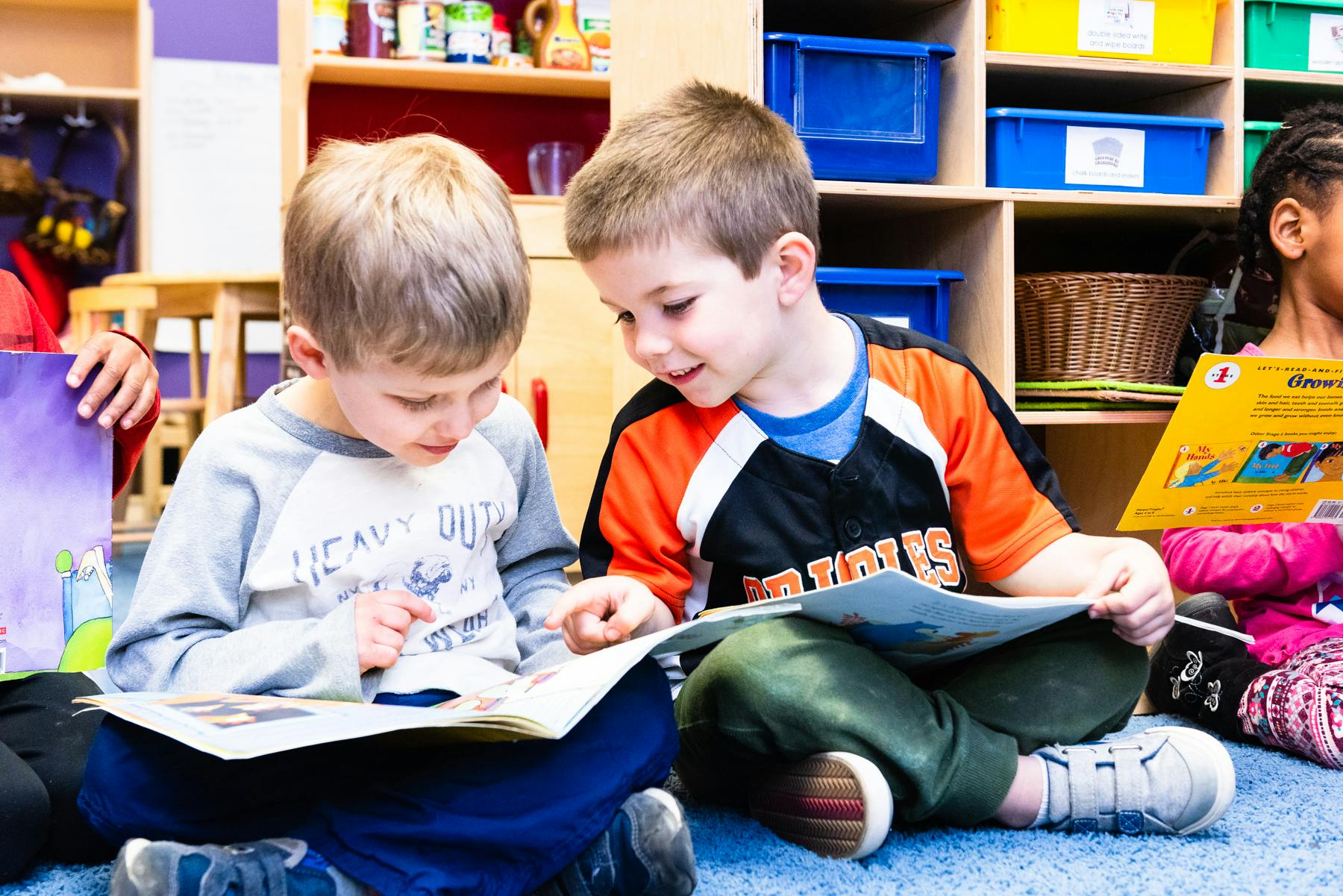 Two children reading books in a classroom