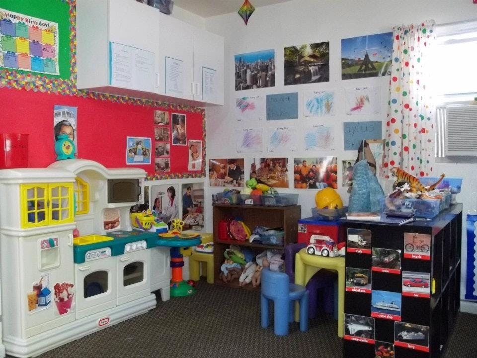 Playroom with a toy kitchen, small chairs, and shelves