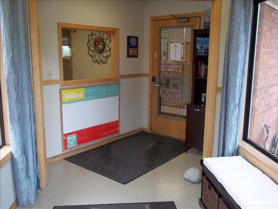 An empty room with a door, windows, and a whiteboard