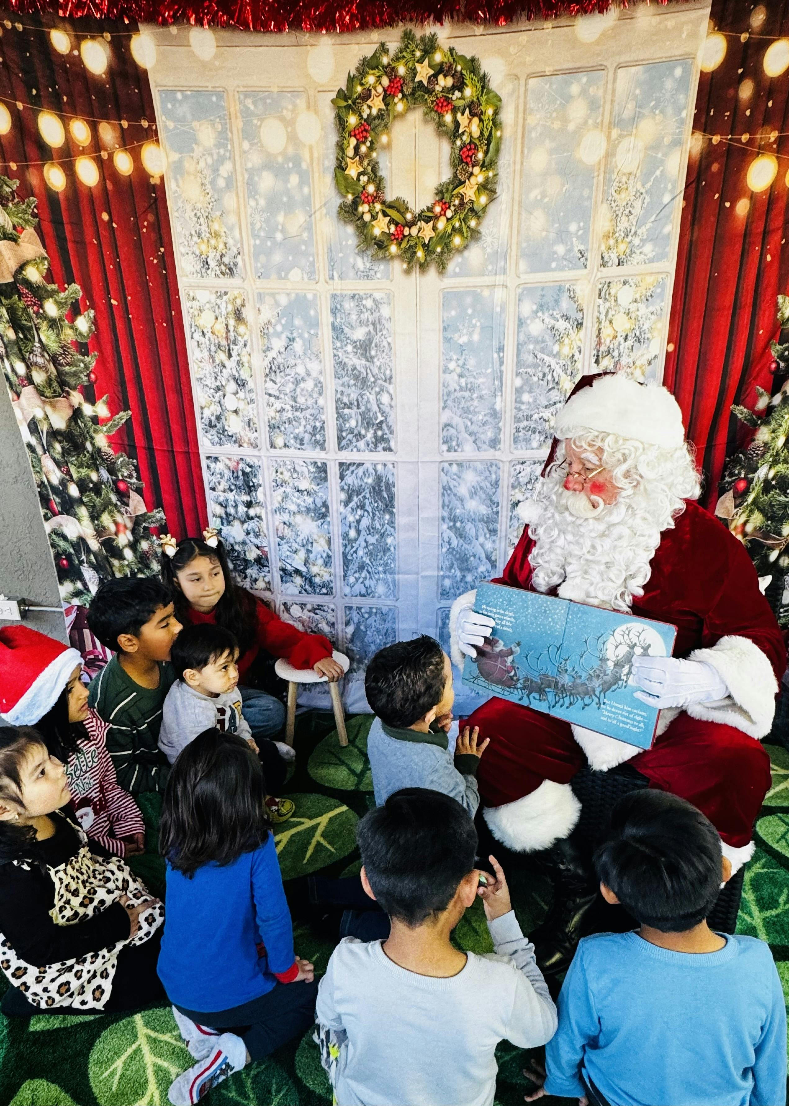 Santa Claus reading a book to a group of children
