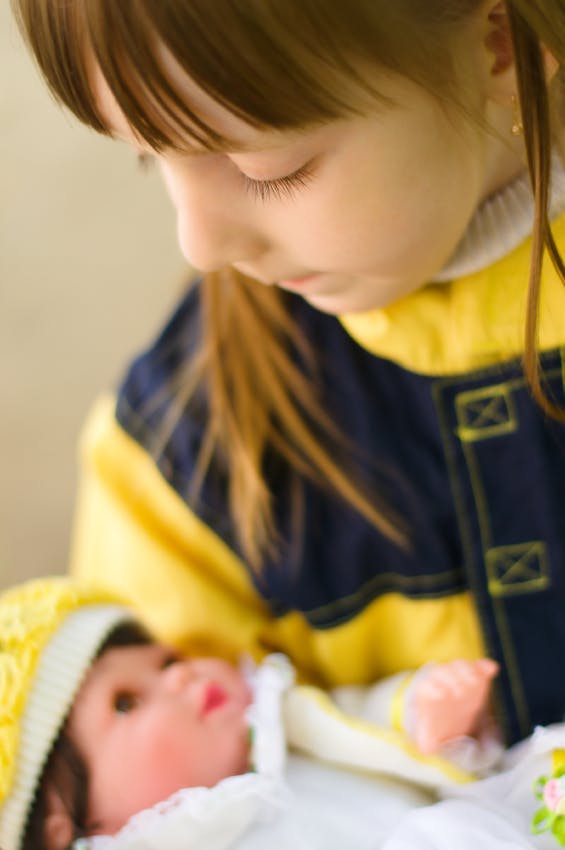 Child looking down at a doll
