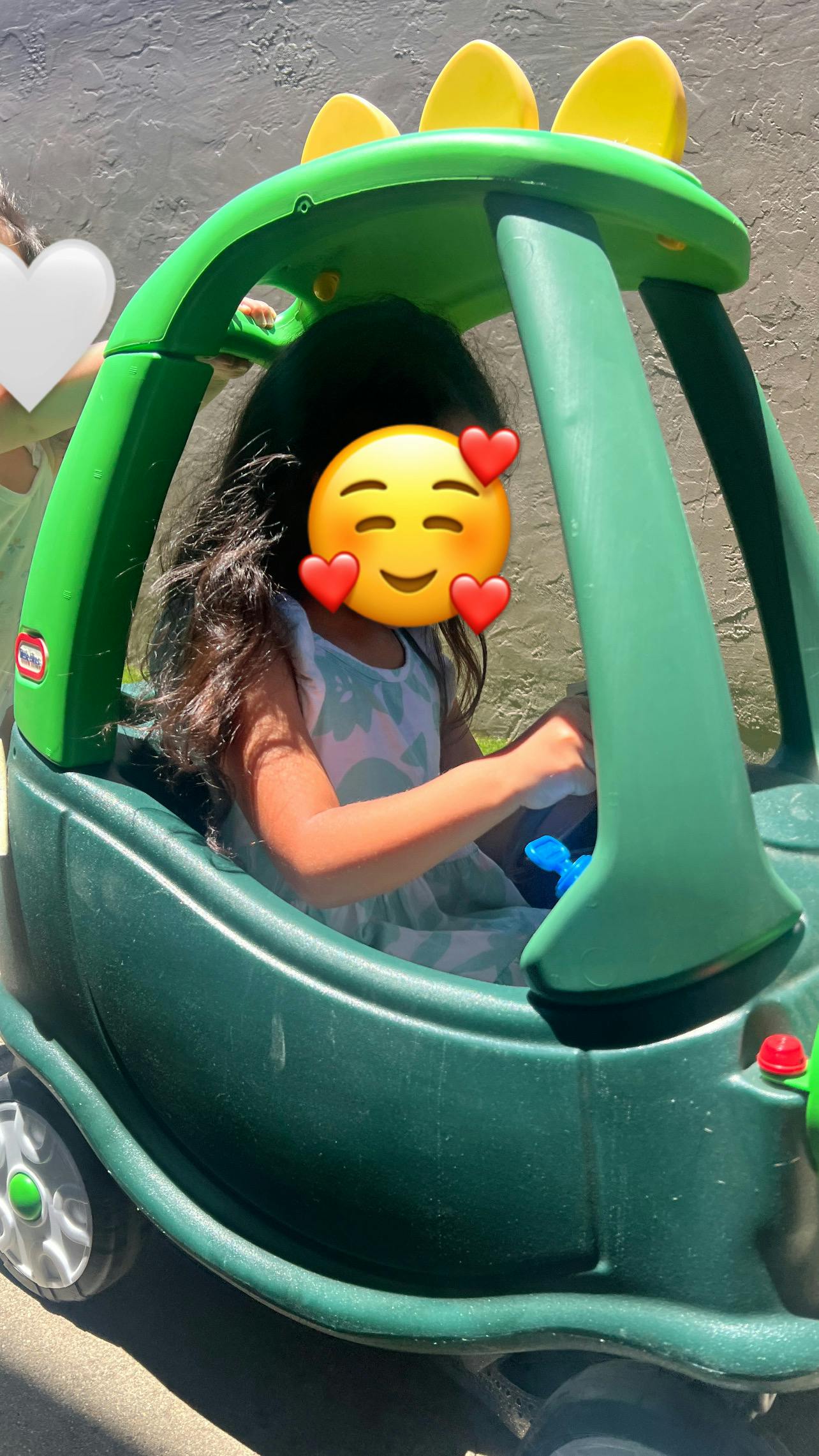 Child sitting inside a toy push car