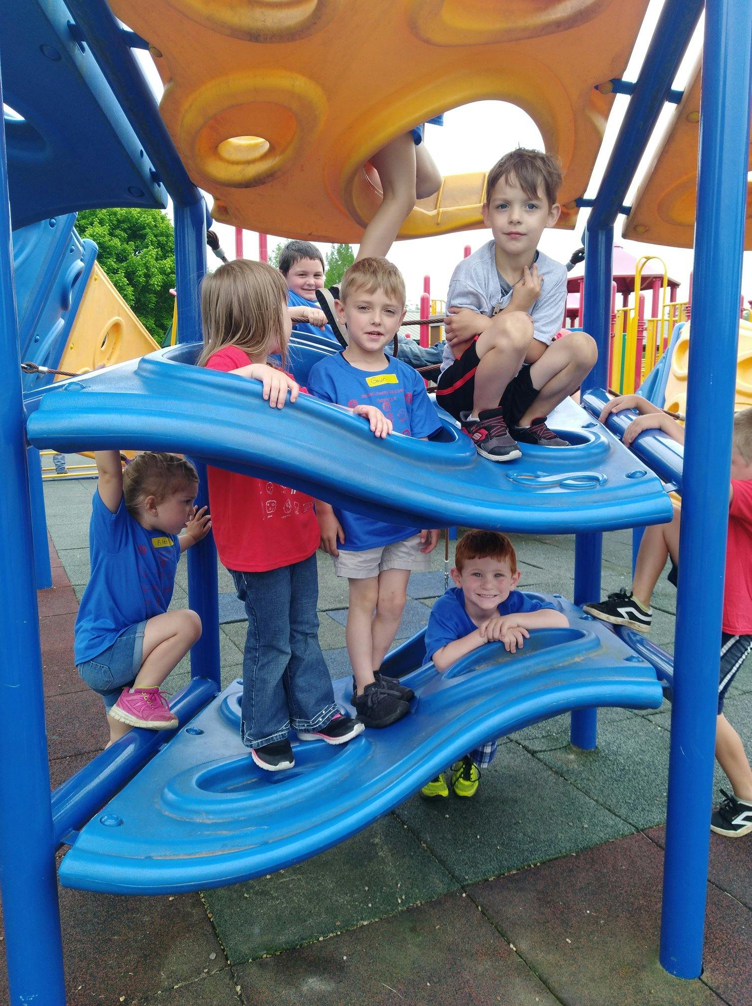 Children playing on a blue and orange playground structure