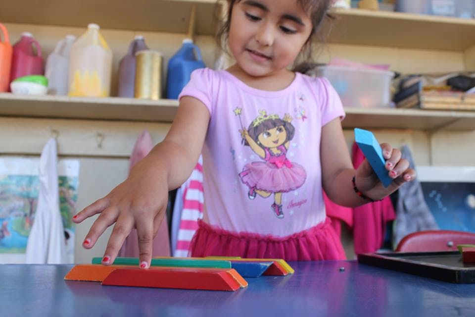 Child playing with colorful blocks on a table