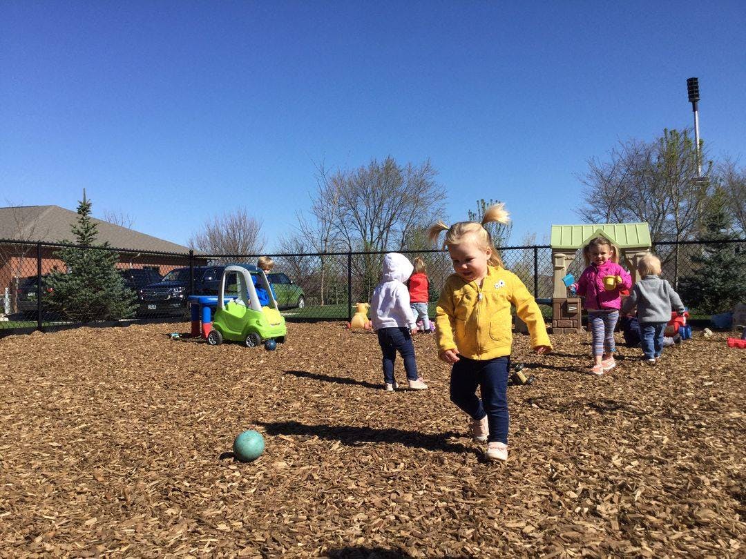 Children playing on a wood chip playground