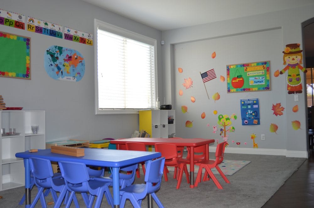Classroom with blue and red tables and chairs, decorated walls