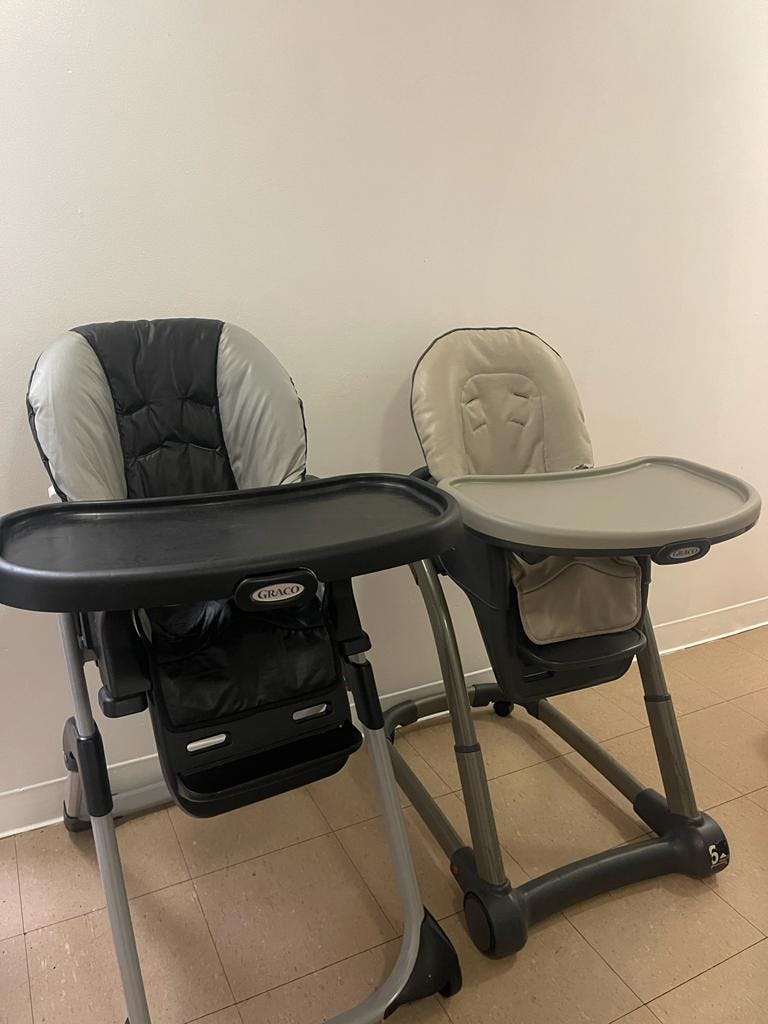 Two high chairs with trays, one dark gray and one light gray