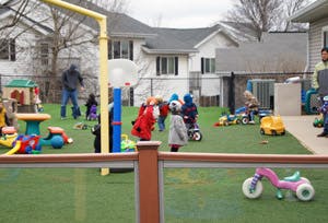 Children playing on a playground with tricycles and play structures