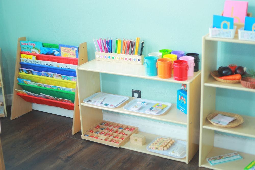 Classroom shelves with books, art supplies, and learning materials