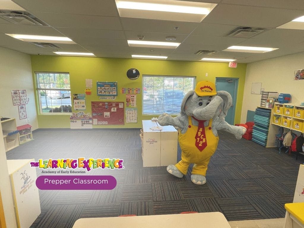 Elephant mascot in yellow overalls and hard hat in a classroom