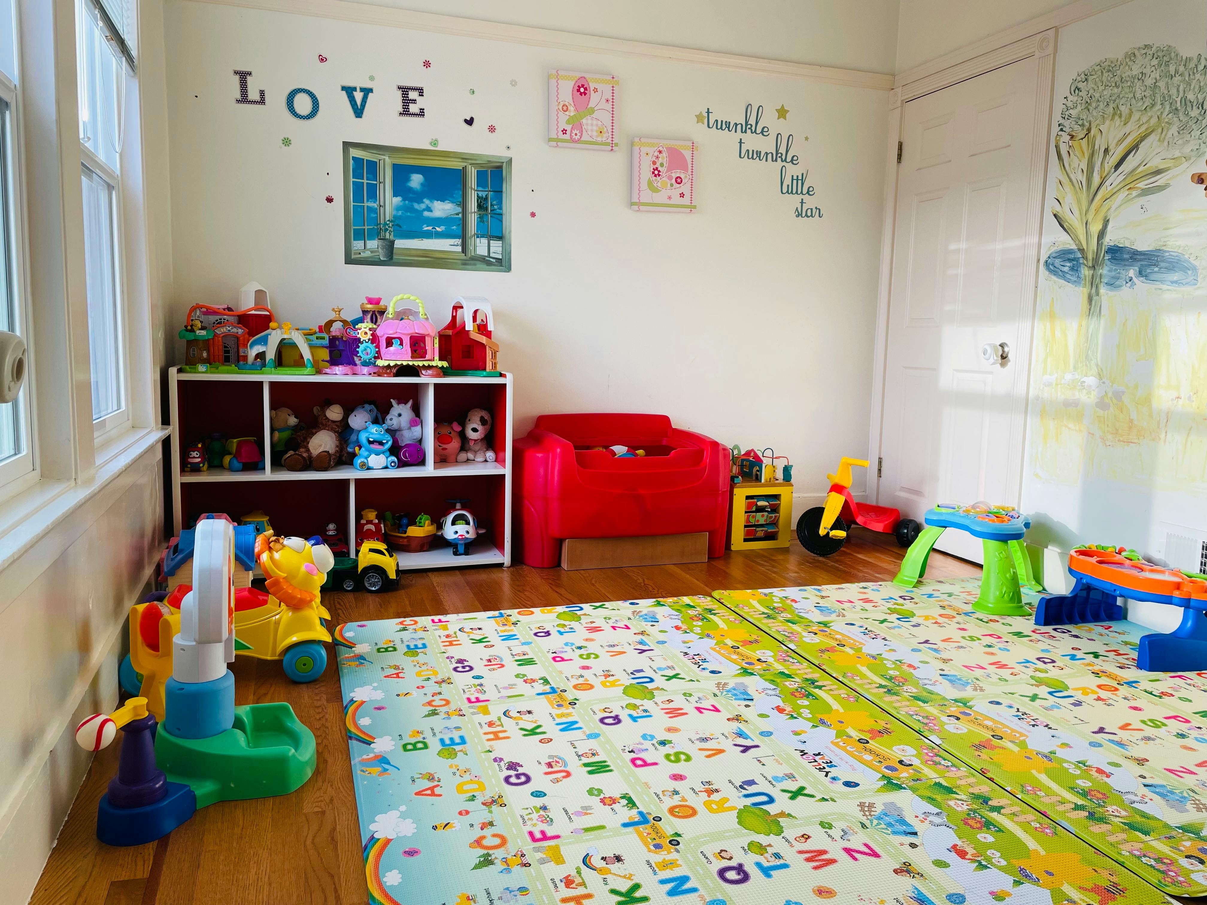 Playroom with toys, storage shelves, and an alphabet playmat
