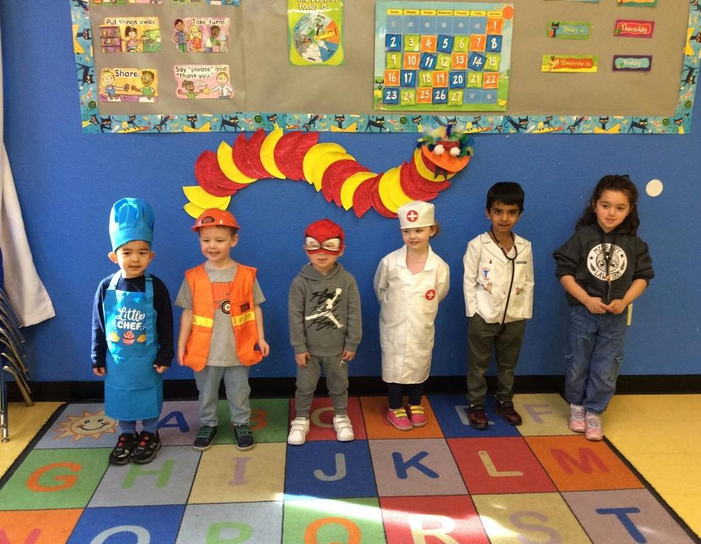 Group of children in various costumes standing in a classroom
