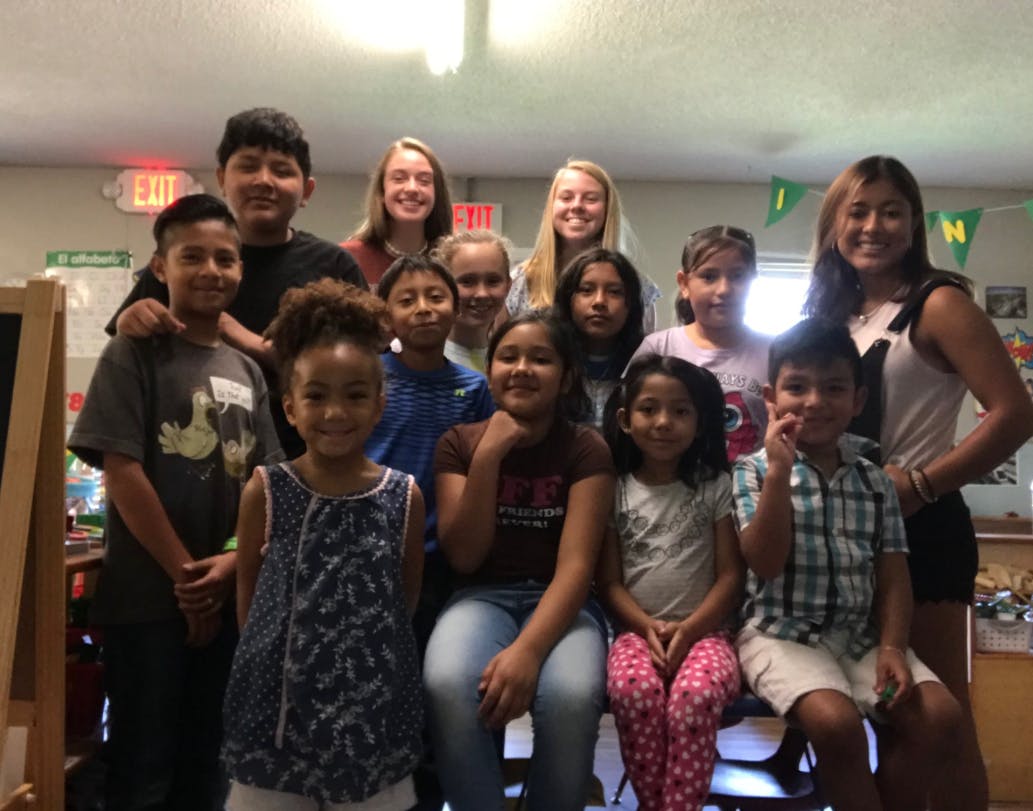 Group of children and teens posing for a photo indoors