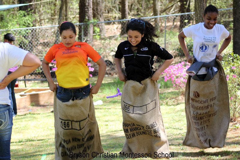 Three people in burlap sacks for a sack race