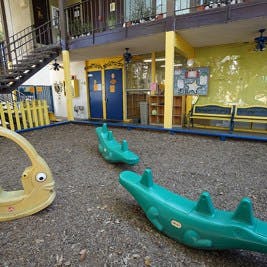 Playground with green seesaws and a yellow swing