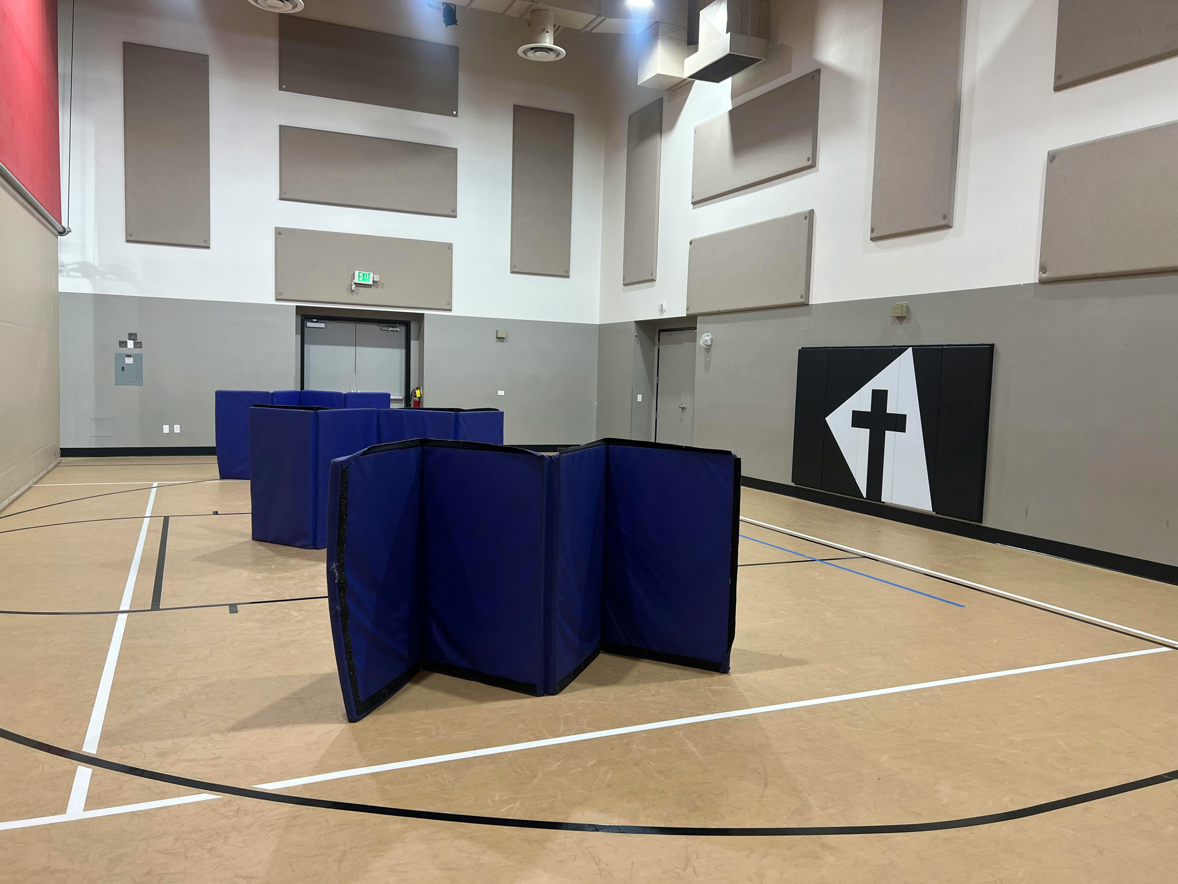 Gymnasium with blue padded barriers on the floor