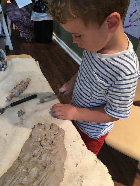 Child working with clay on a table