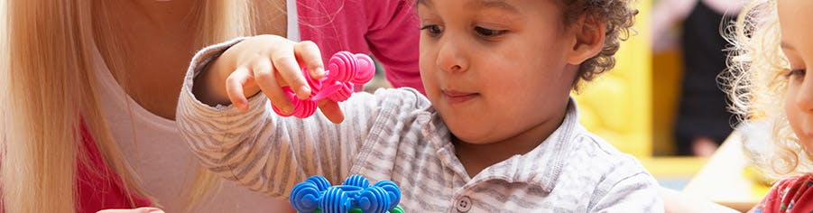 Child playing with colorful interlocking toys