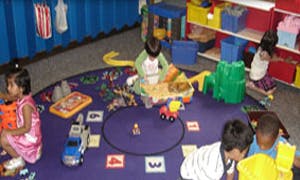 Children playing with toys on a rug in a classroom