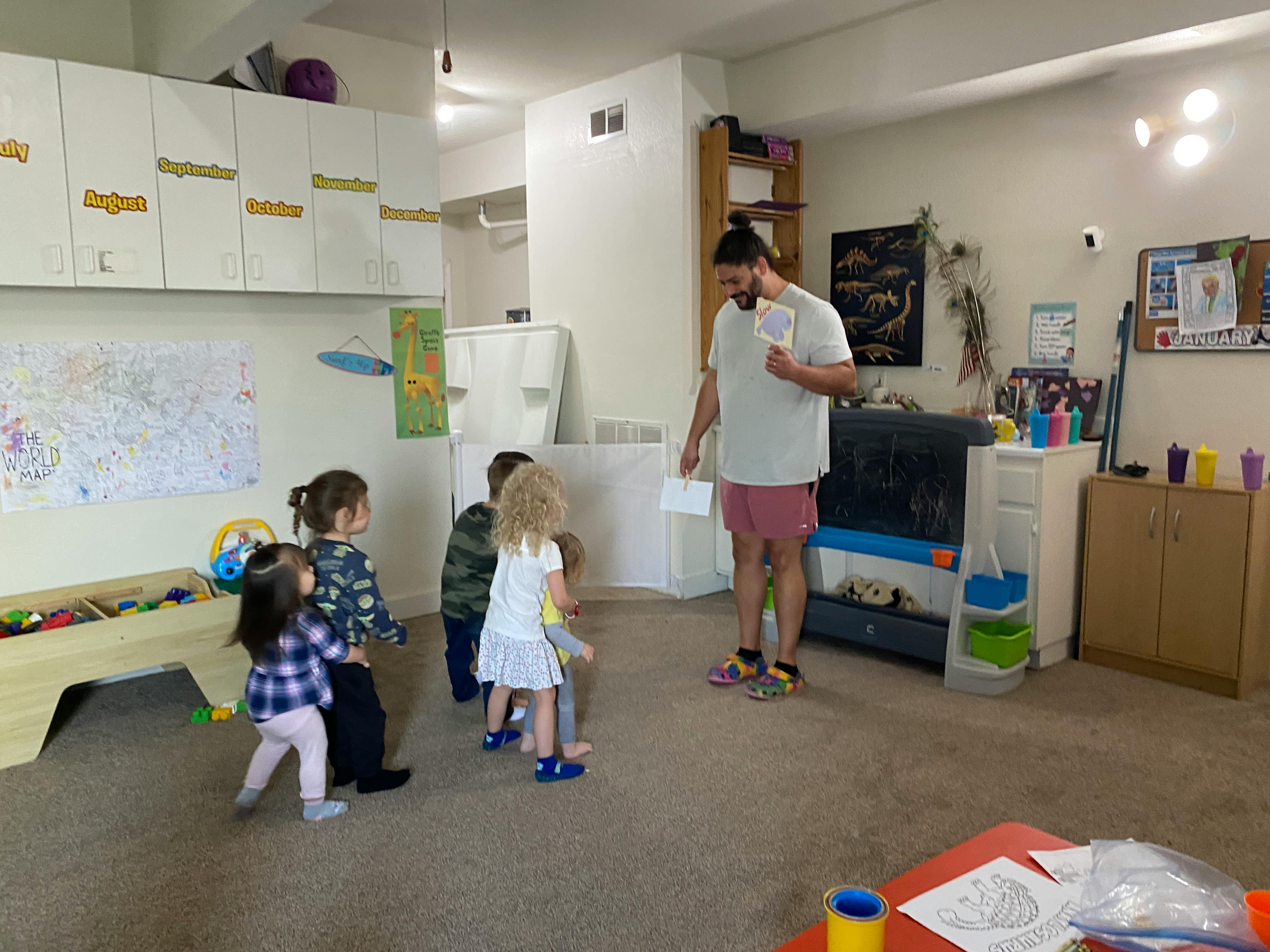 Adult person holding papers with children in a room