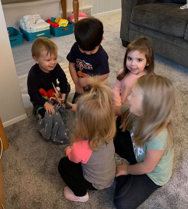 Five children sitting on a carpeted floor