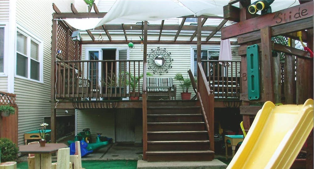 Backyard deck with stairs leading to a play structure and slide