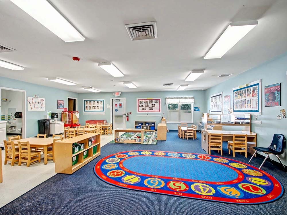 Empty colorful children's classroom with small tables and chairs