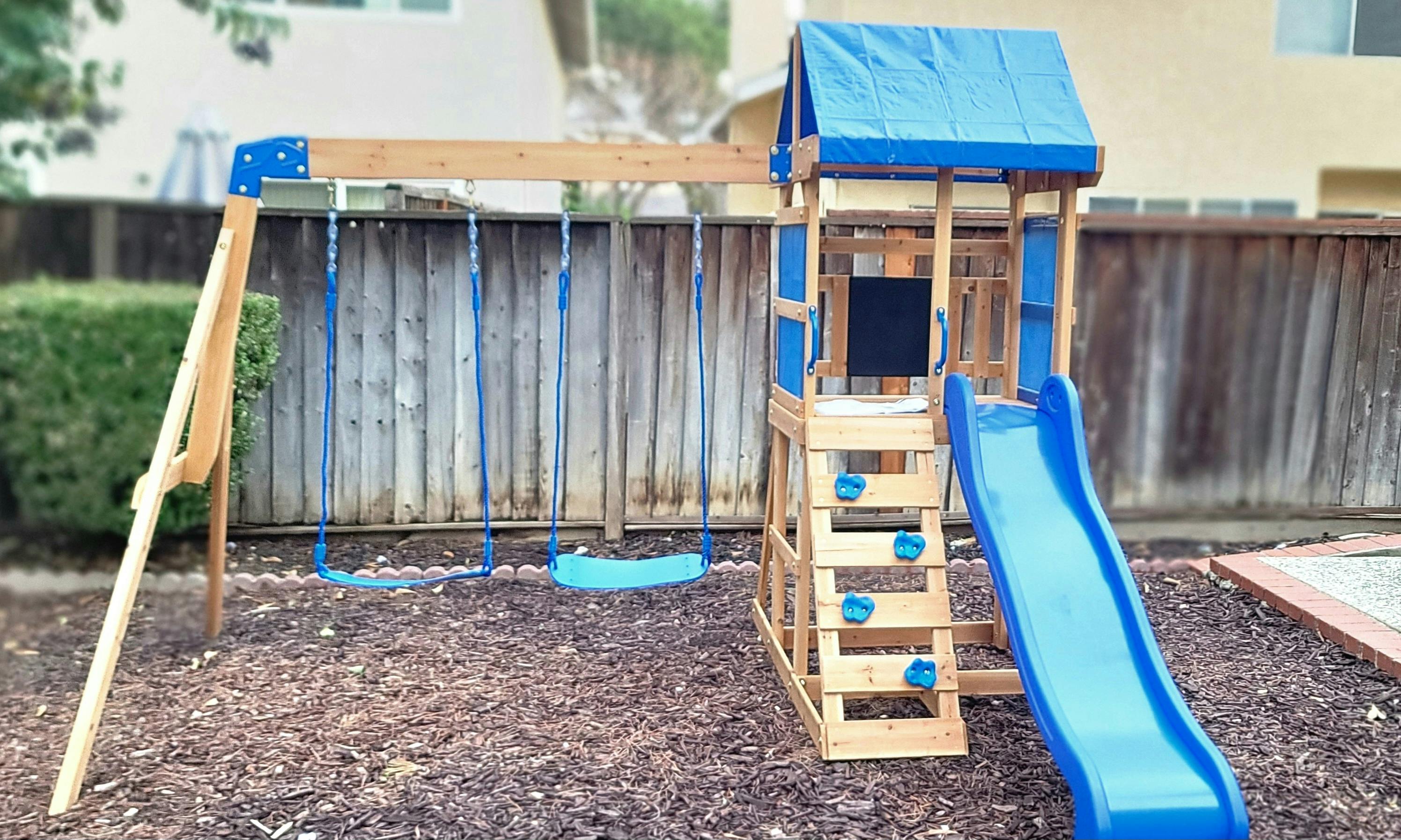 Wooden playset with swings and a slide