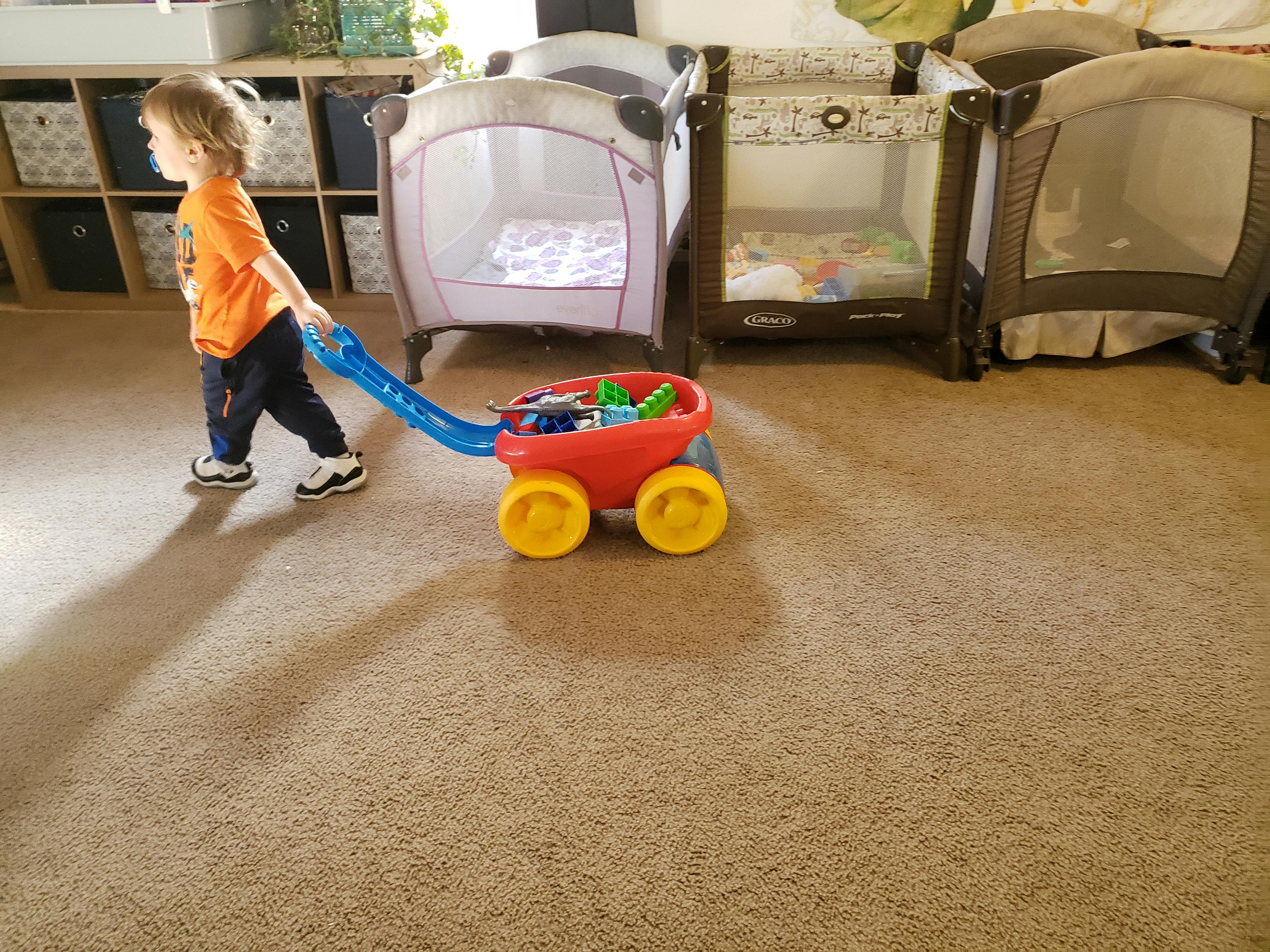 Child pulling a toy wagon with blocks