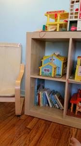 Wooden shelf with toy houses and books