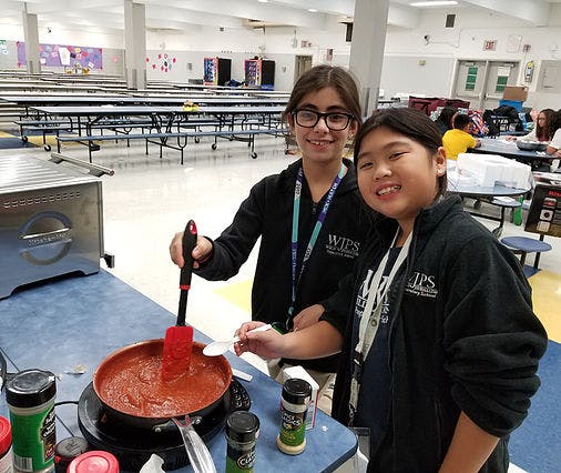 Two children cooking in a large room
