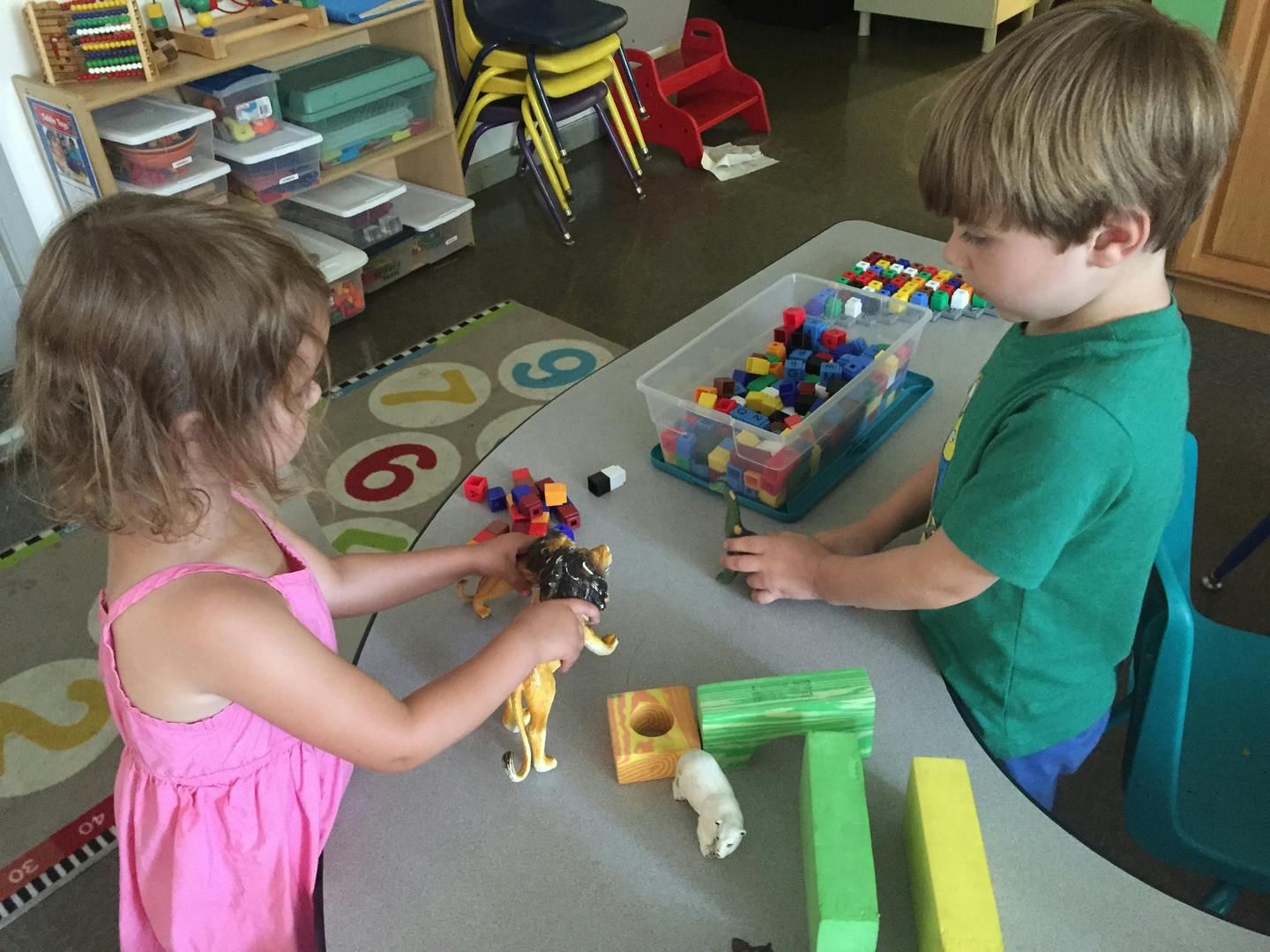 Two children playing with toys at a table