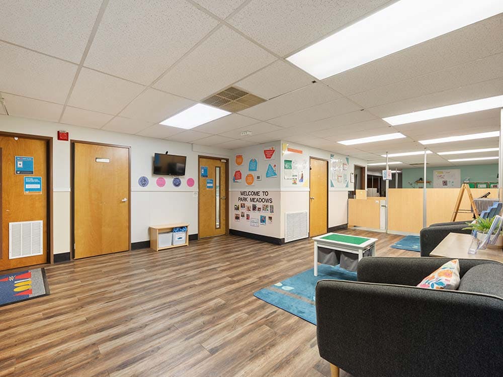 Lobby area with wood-look flooring, multiple doors, and a seating area