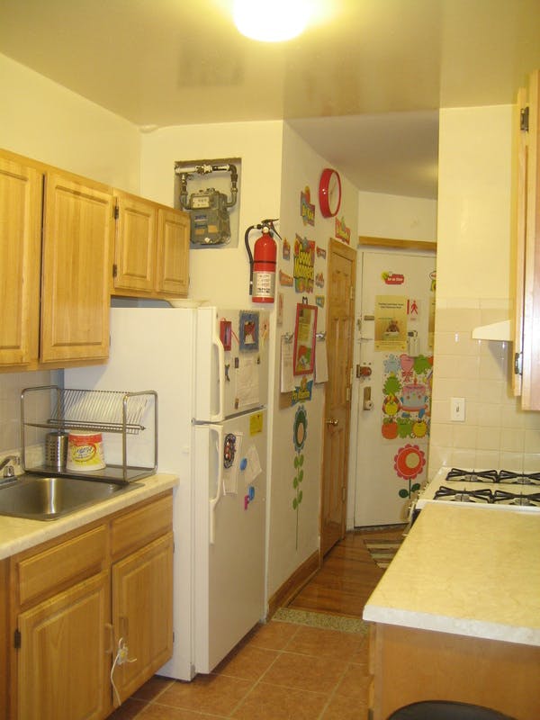 Kitchen with wooden cabinets, white appliances, and a fire extinguisher