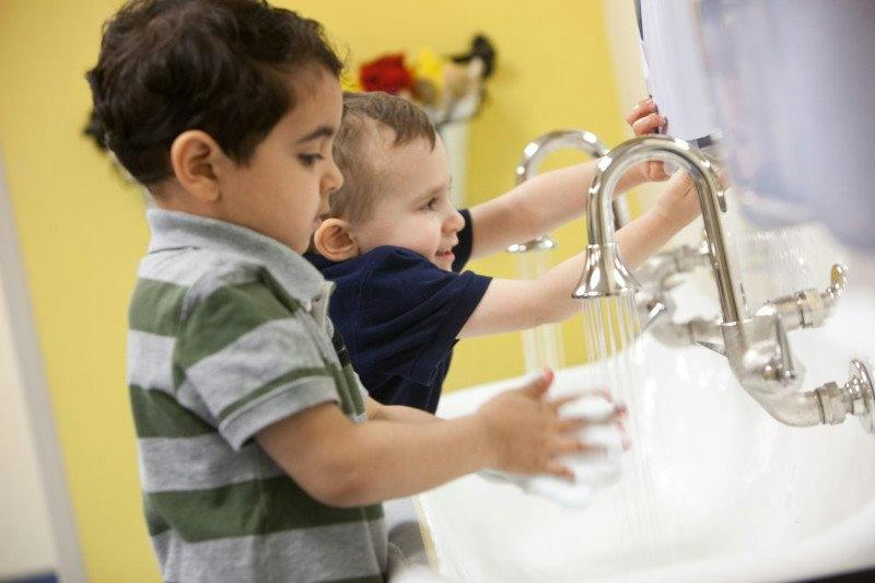 Two children washing hands at a sink