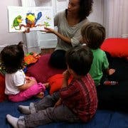 Person reading a book to three children