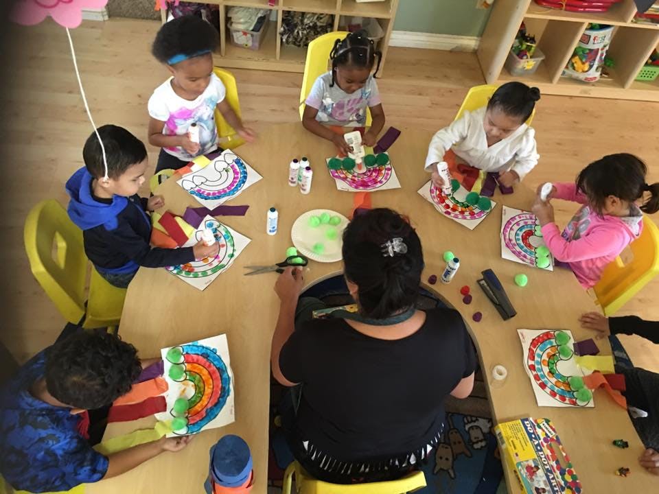 Adult and children doing crafts at a table