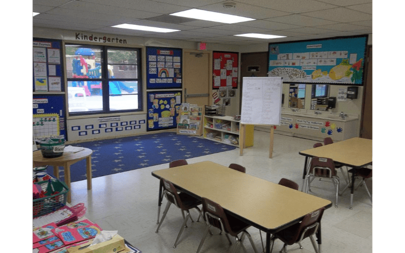 Empty kindergarten classroom with small tables and chairs