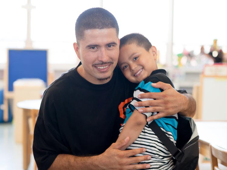 Person holding a child in a classroom