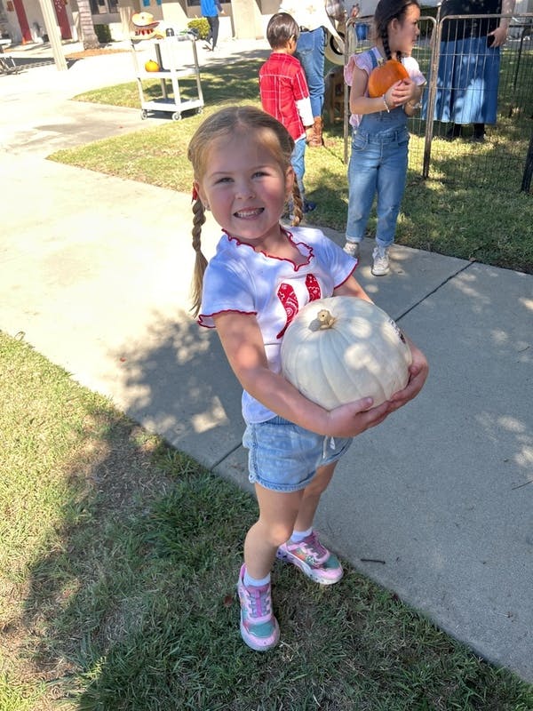 Child holding a white pumpkin