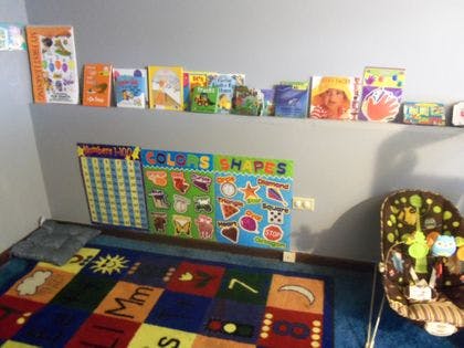 Children's learning area with books, a colorful rug, and educational posters