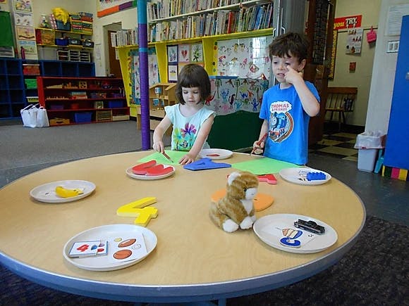 Two children at a table with craft supplies