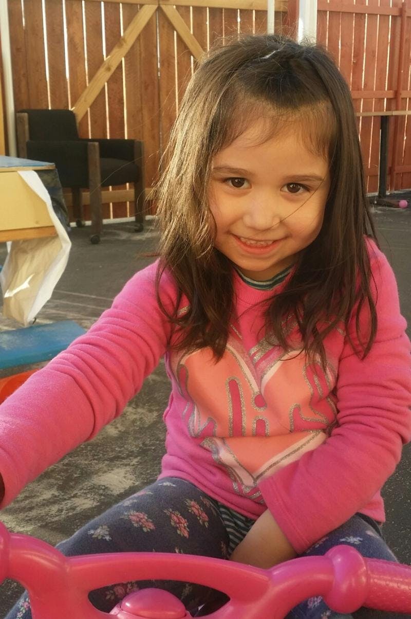Child in pink shirt on a toy