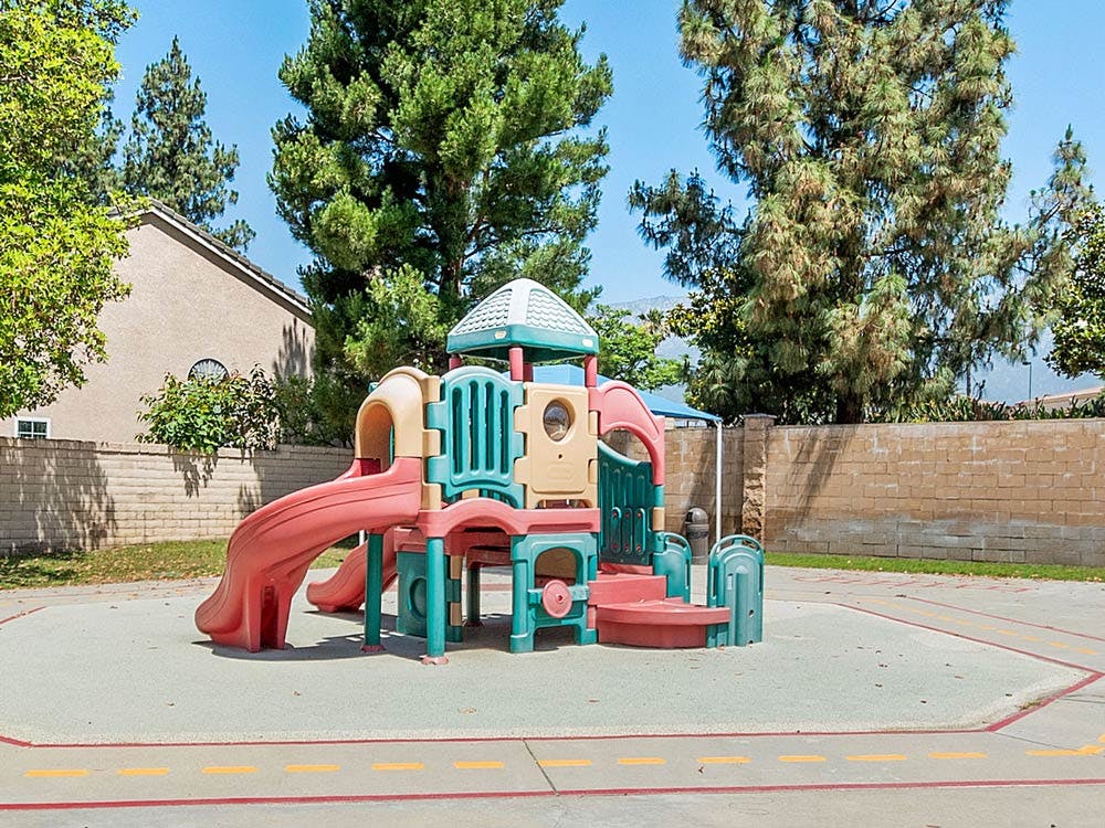 Playground equipment with slides and climbing structures in a park
