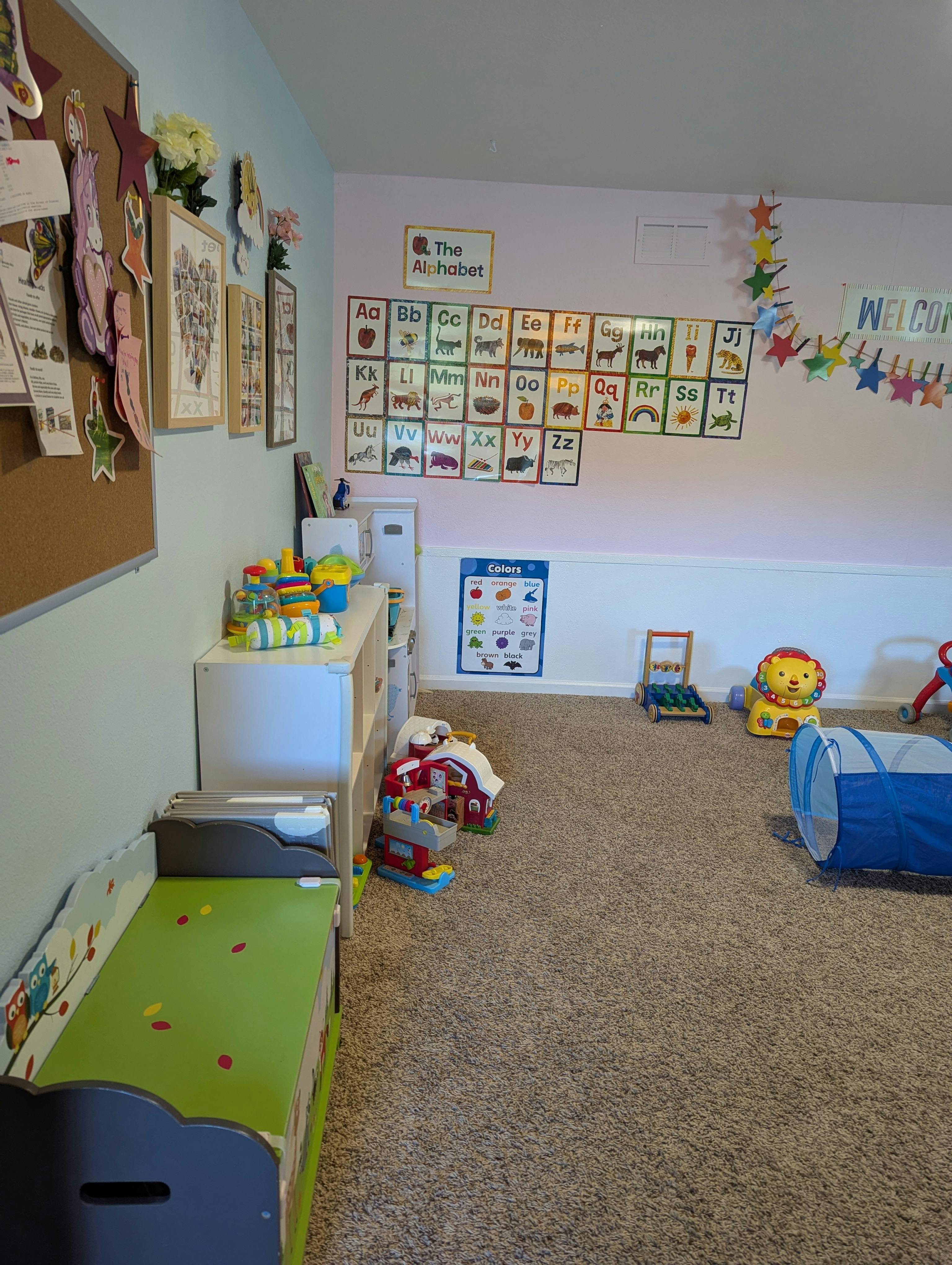 Playroom with alphabet chart, toys, and a blue tunnel