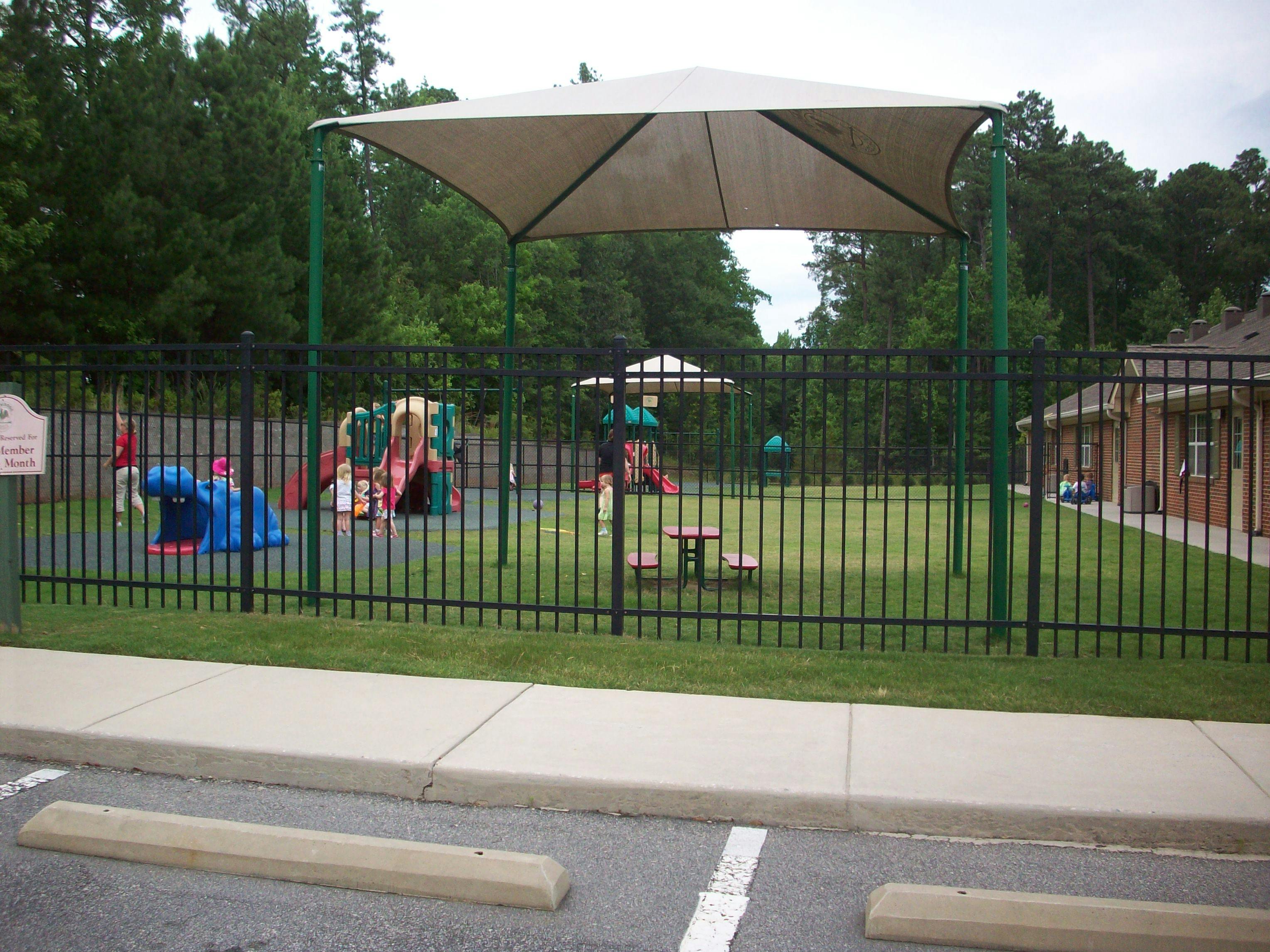 Playground with children playing behind a fence
