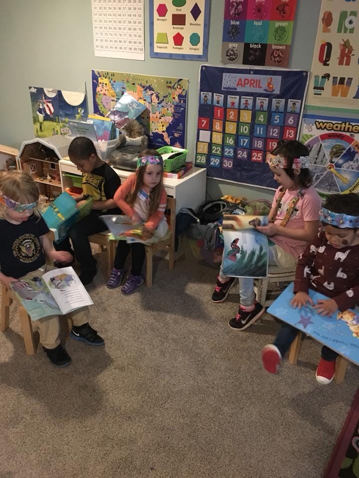 Children sitting in a classroom reading books