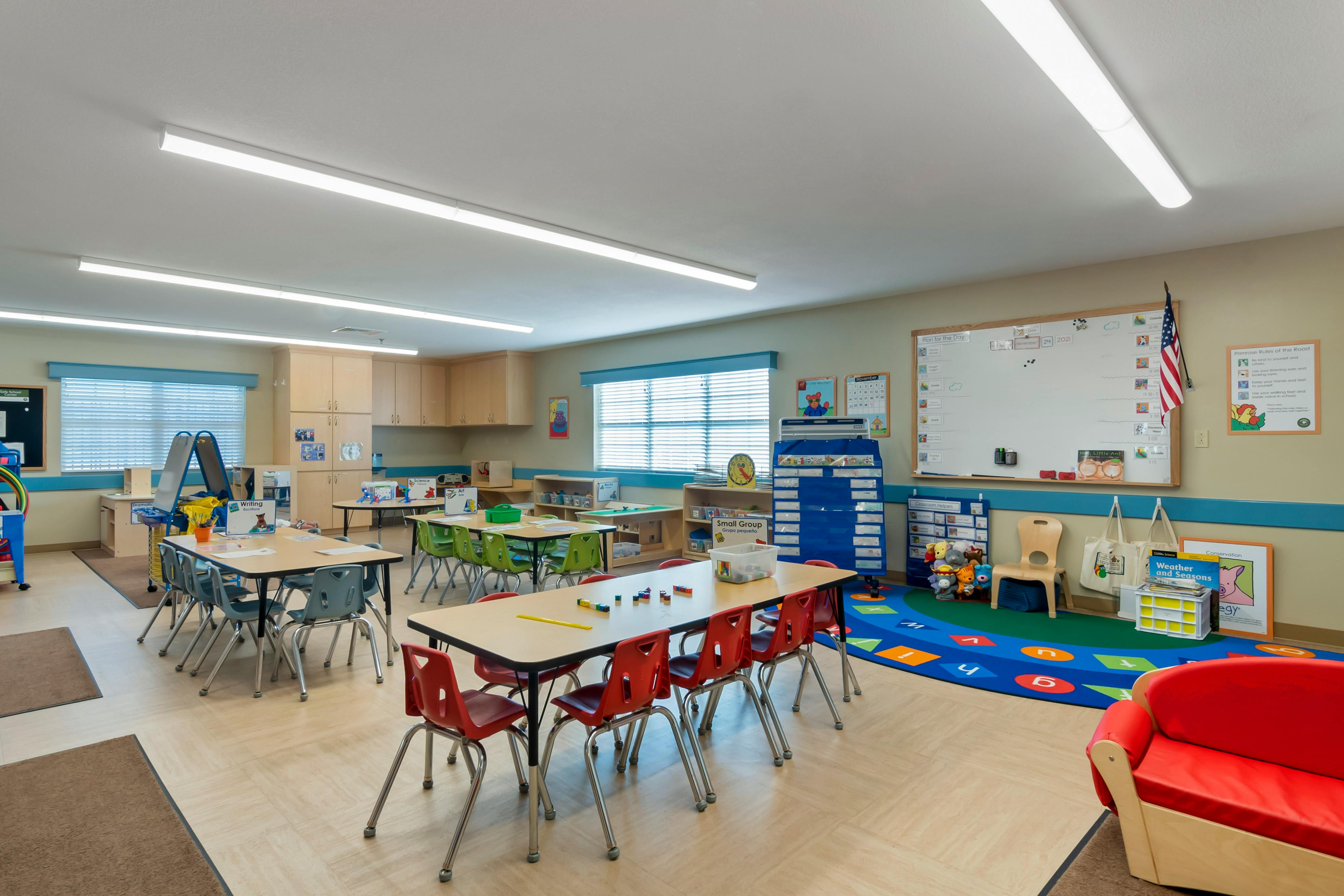 Empty classroom with small tables and chairs, and learning materials