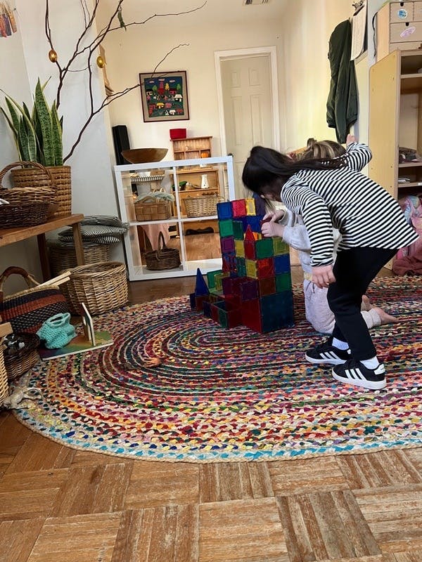 Child playing with colorful building blocks on a rug